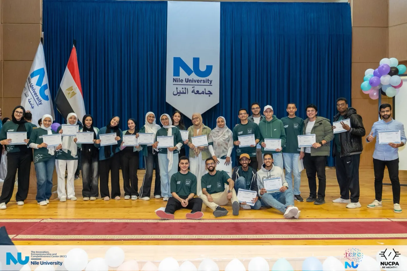 The full contest cohort and organisers on stage with balloons and certificates