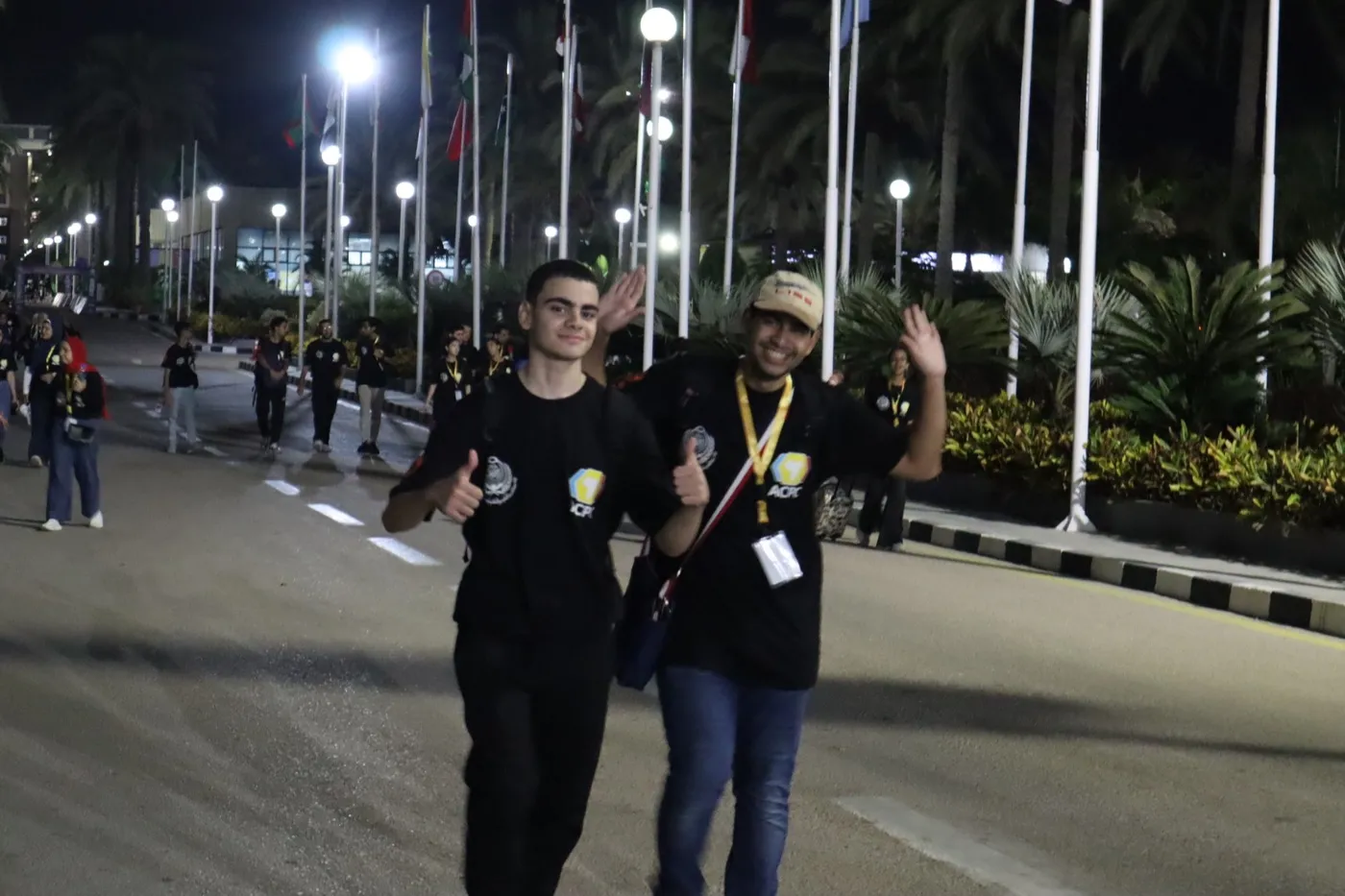 Two students walking down a lit avenue at night after a contest