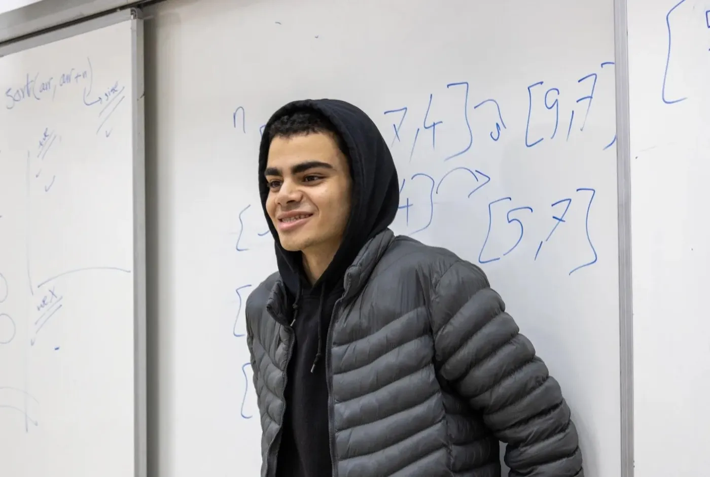 A student in front of a whiteboard covered in interval notation